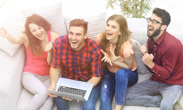 Grupo de amigos viendo un vídeo en un ordenador portátil y riendo — Foto de Stock
