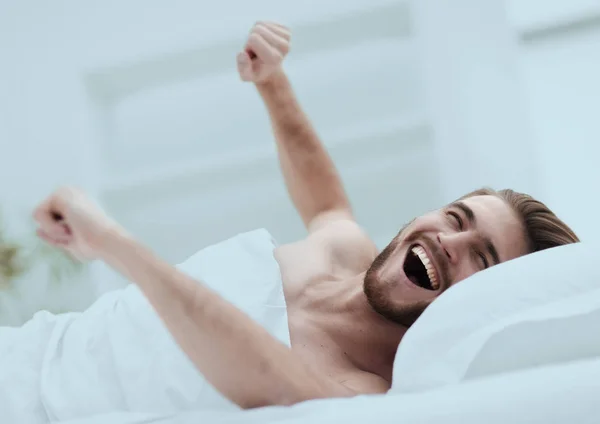 Šťastný muž, probuzení v pohodlný pokoj — Stock fotografie