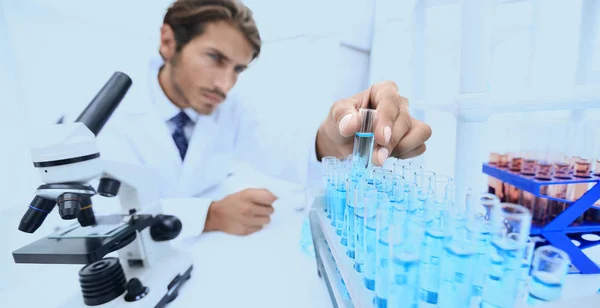 Chemik, patrząc na probówki niebieski płyny — Zdjęcie stockowe