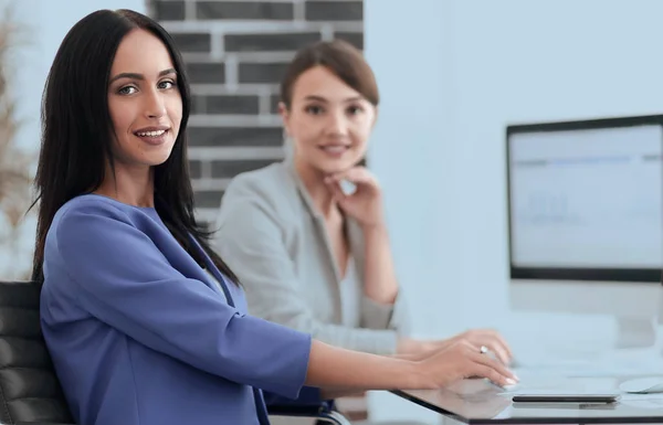 Young woman looking at camera and smiling sitting at workplace — Stock Photo, Image