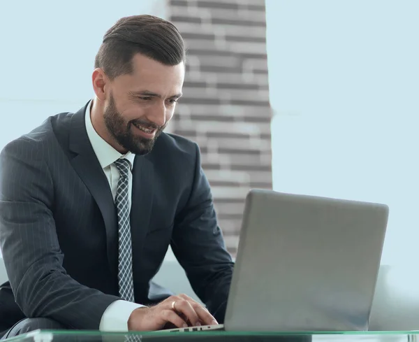 Homme d'affaires travaillant sur un ordinateur portable assis sur un canapé dans un bureau — Photo