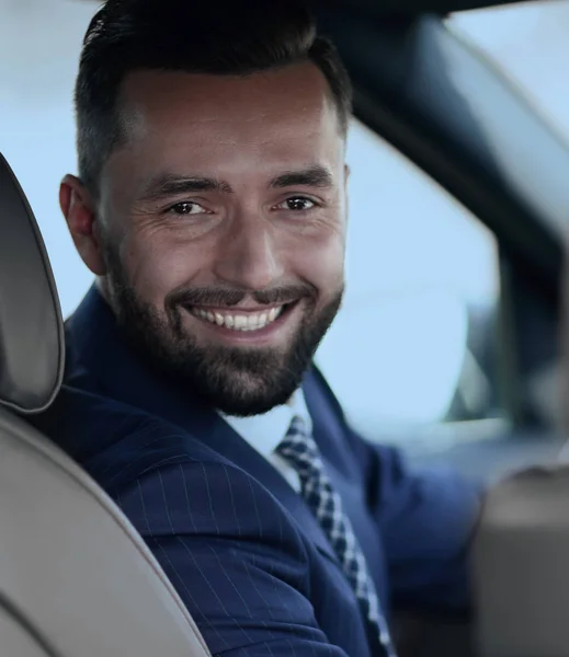 Close-up of a businessman sitting at the wheel of a car — Stock Photo, Image