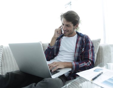 genç adam finansal belgeler evde tartışırken laptop ile çalışma.