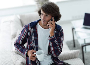 güzel bir fincan adamla bir dizüstü bilgisayar önünde oturur.