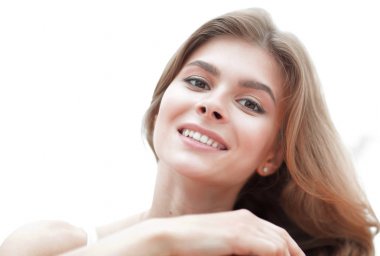 Hafif makyajlı gülümseyen genç bir kadının yakın plan portresi.