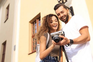 Fotoğraflara bakarak yürüyen genç arkadaşların portresi