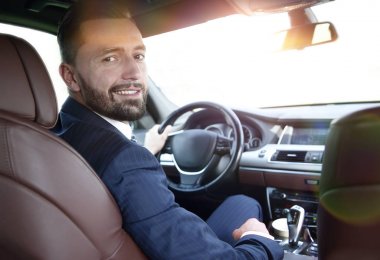 businessman sitting at the wheel of a prestigious car clipart