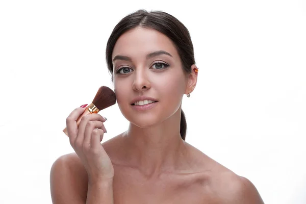 Nahaufnahme einer schönen Frau mit einem Make-up-Pinsel — Stockfoto