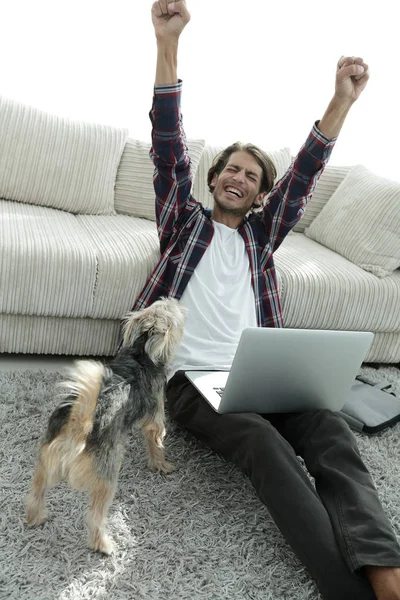 Chico feliz con el ordenador portátil jubiloso en la amplia sala de estar . —  Fotos de Stock