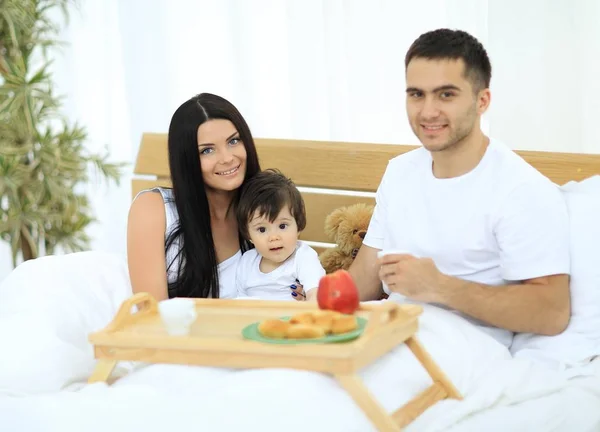 Famille prenant le petit déjeuner au lit à la maison — Photo