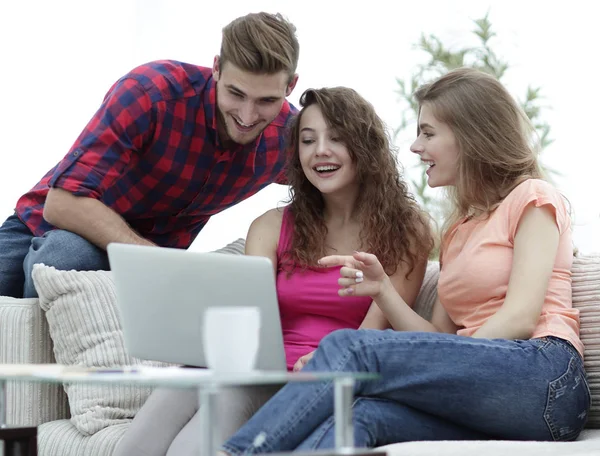 Groupe d'étudiants regardant un écran d'ordinateur portable, assis sur le canapé — Photo