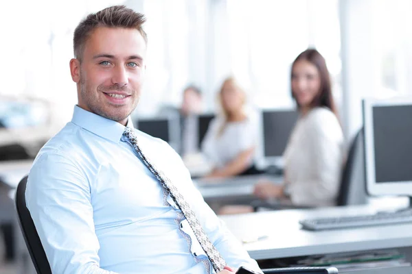 Empleado exitoso sentado detrás de un escritorio y mirando a la cámara . — Foto de Stock