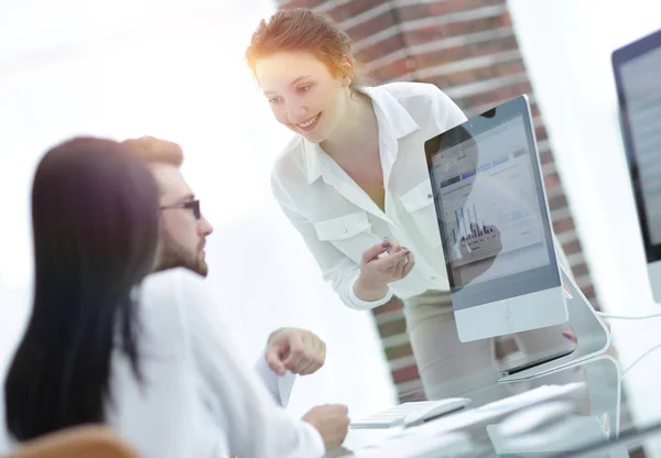 Especialistas de la empresa discutiendo los horarios financieros en el escritorio — Foto de Stock