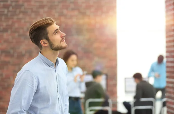 Joven hombre de negocios mirando hacia otro lado mientras trabaja en la oficina . — Foto de Stock