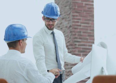 yeni bir projeyi tartışmak üzere mimar ve inşaat ustabaşı