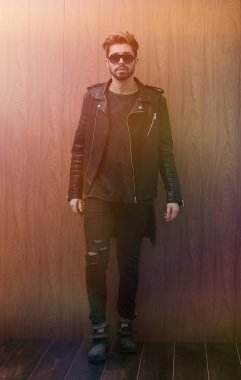 Siyah deri ceketli ve kot pantolonlu bir adam