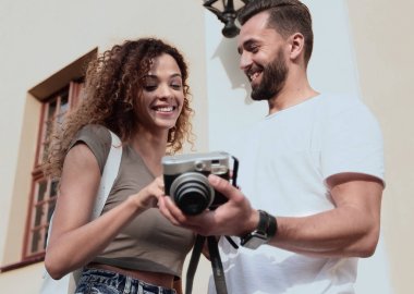 Fotoğraflara bakarak yürüyen genç arkadaşların portresi