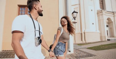 Bir çift şehrin sokaklarında yürüyor ve eğleniyor.