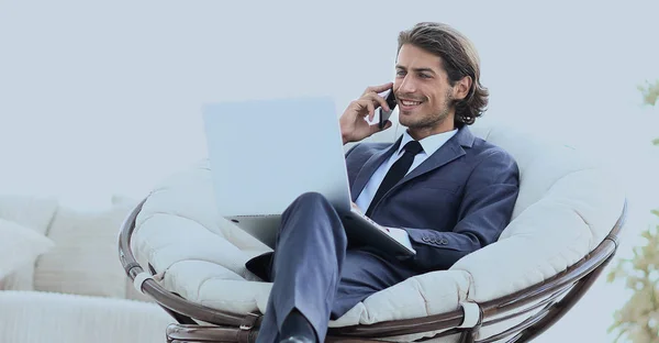 リビング ルームに座っているスマート フォンに話しているビジネス男性 — ストック写真