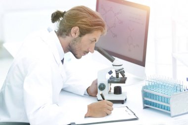 Laboratory worker sitting by table with microscope clipart