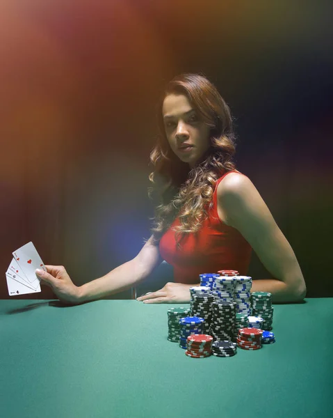 Pretty young woman gambling on green table — Stock Photo, Image