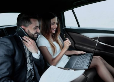 Genç iş adamları arabada birlikte çalışıyorlar.