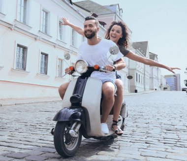 mutlu genç bir çift bir scooter üzerinde eğleniyor