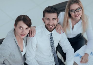masada oturan ve kameraya bakarak başarılı iş takım.