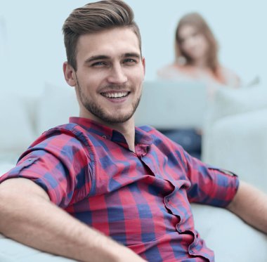 başarılı bir genç adam rahat bir sandalyede oturuyor closeup