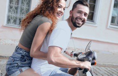 mutlu genç bir çift bir scooter üzerinde eğleniyor