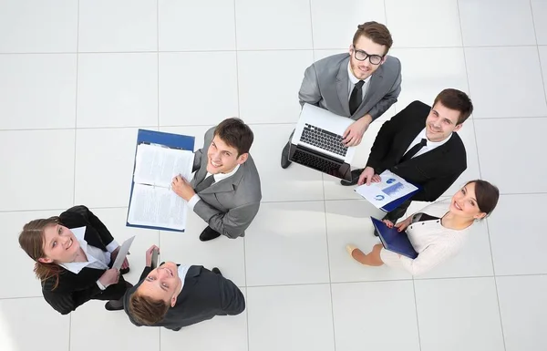 Бизнес-команда с финансовыми документами, стоящими в холле — стоковое фото