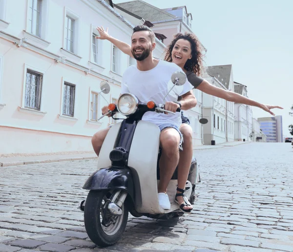 Felice giovane coppia divertirsi su uno scooter — Foto Stock