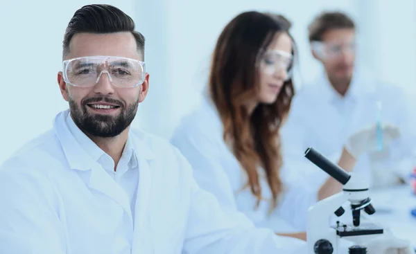 Microbiologist and his colleagues are sitting in a modern labora — Stock Photo, Image