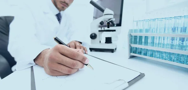 Scientist makes a note of experiment in the laboratory — Stock Photo, Image