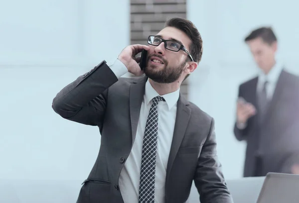Уверенный молодой человек разговаривает по телефону в офисе — стоковое фото
