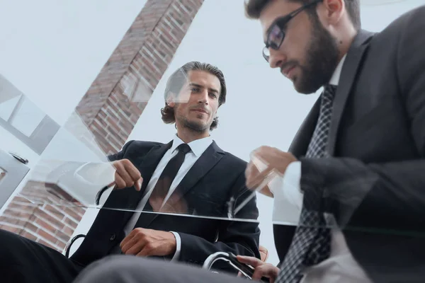 Geschäftspartner sitzen am Schreibtisch — Stockfoto