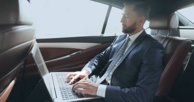 İş adamı arabaya otururken dizüstü bilgisayar ile çalışma