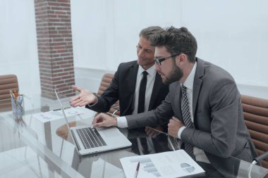 dizüstü bilgisayarda çalışan iki iş adamları.