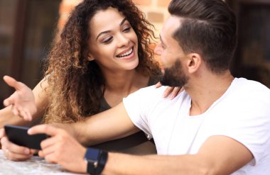 Seven bir terasta yer oturan bir smartphone kullanarak çift mutlu