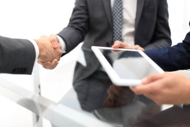 Bir toplantı sırasında el sıkışan iki emin iş adamları