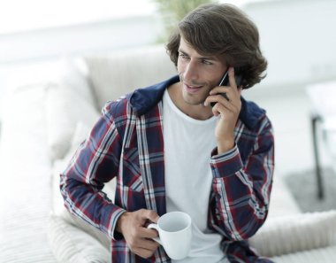 güzel bir fincan adamla bir dizüstü bilgisayar önünde oturur.