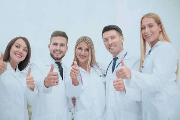 Portrait of a doctor and medical team showing thumb up — Stock Photo, Image