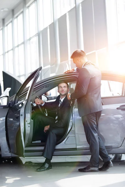 Businessman receives from the Manager the keys,sitting behind the wheel of a new car. — Stock Photo, Image