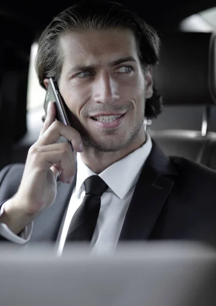 Podnikatel v autě s notebookem mluvil po telefonu — Stock fotografie