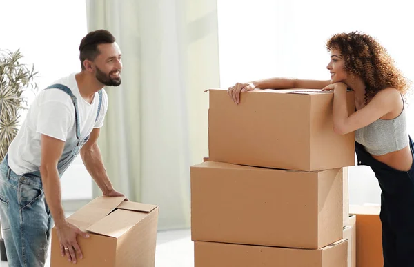 Jovem casal desempacotar caixas em uma nova casa — Fotografia de Stock