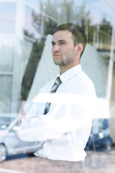 Vista desde detrás de glass.confident hombre de negocios mirando por la ventana de su oficina — Foto de Stock