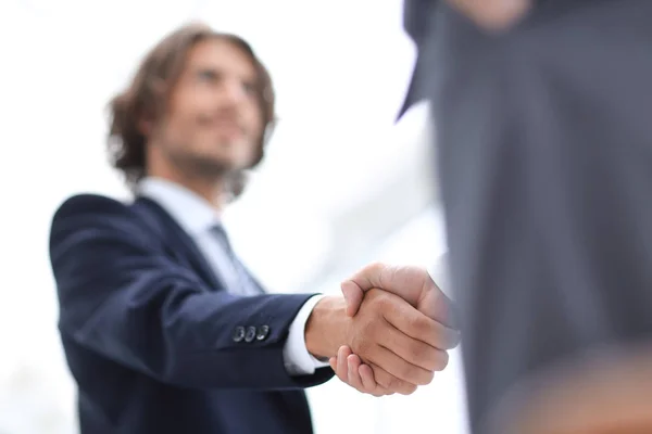 Два бизнесмена пожимают друг другу руки приветствуя друг друга — стоковое фото