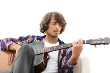 Yakışıklı adam evde kanepede gitar çalmaya