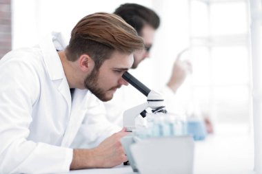 Serious clinician studying chemical element in laboratory