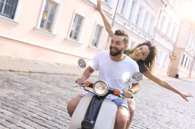 mutlu genç bir çift bir scooter üzerinde eğleniyor